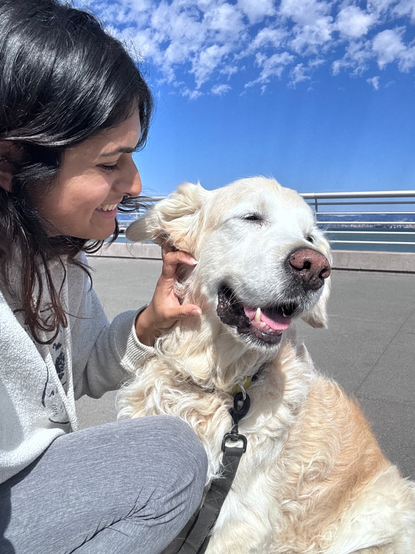 Sonal Ravi smiling with Chester, her Golden Retriever