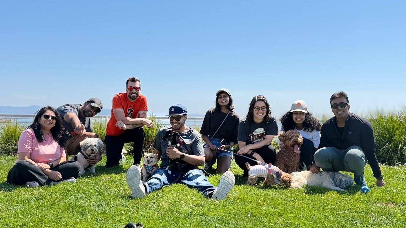 A group of community members and their dogs sitting together on a lawn